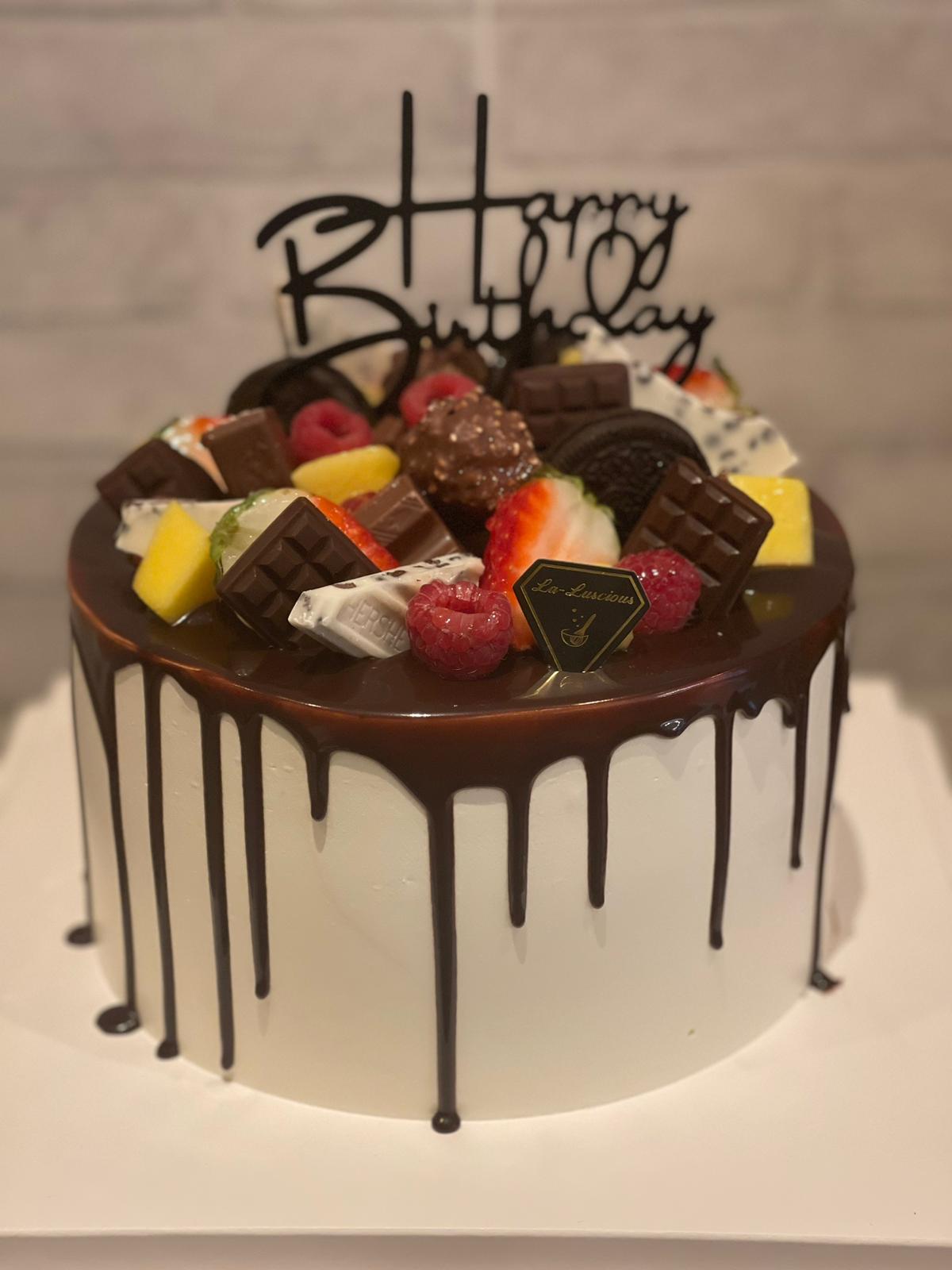 Chocolate drip cake finished with sweets and chocolate bars, La-Luscious Bakery Grays